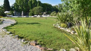 Un jardín bien cuidado con césped, una zona de estar y un camino que lleva a un edificio.