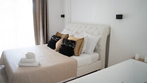 Una habitación de hotel con cama, mesita de noche y baño con bañera.