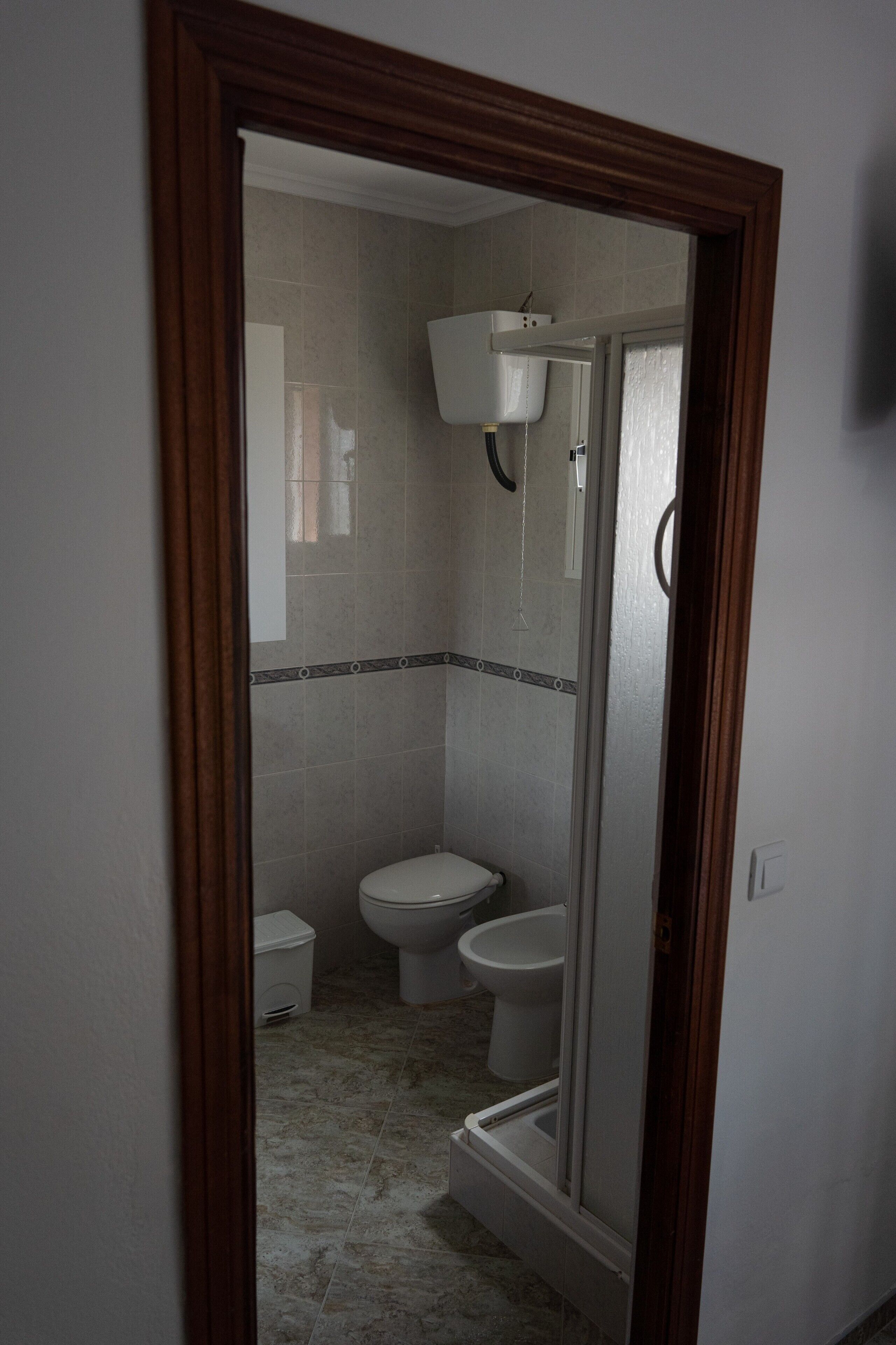 Ein Badezimmer mit Toilette, Bidet und Duschkabine.