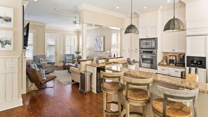 A spacious kitchen with a central island, bar stools, and modern appliances.