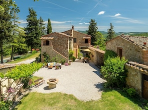 A stone building with a patio area, outdoor seating, and a fire pit.