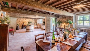 A rustic dining area with wooden tables, stone walls, and exposed beams. - Air Conditioned 10 Bedrooms Luxury Villa and Pool in Lucca (Capannori)