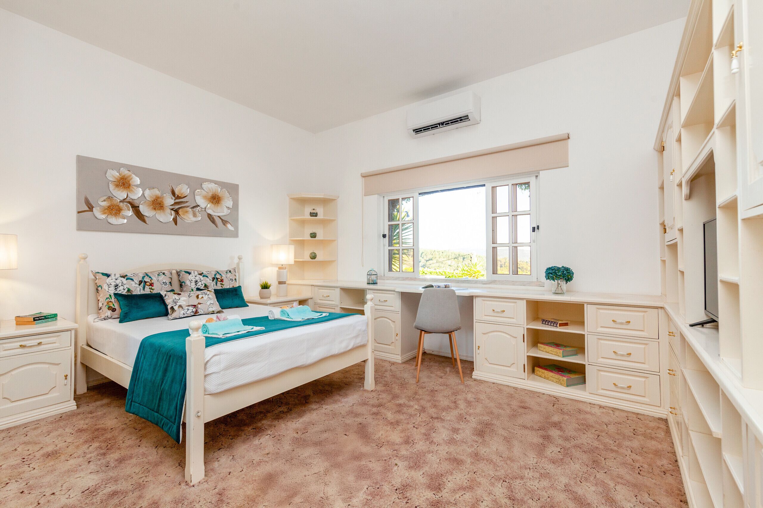 Una camera da letto con un letto, una scrivania, una sedia e scaffali.