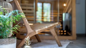 Ein Zimmer mit Holzboden, einem Hängekorbstuhl, einem Topfpflanzen und einer kleinen Dekorationsvase.