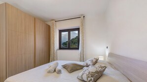 Un dormitorio con una cama grande, una ventana con cortinas y un armario de madera.