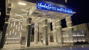 L’entrée d’un hôtel, avec une enseigne bien visible indiquant « Shada Hotel » et un texte en arabe.