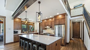 Una cocina moderna con una isla grande, electrodomésticos de acero inoxidable y armarios de madera.