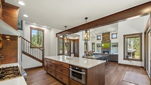Una cocina amplia con una isla grande, armarios de madera y un horno empotrado.