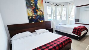 Habitación de hotel con dos camas, un cuadro abstracto grande en la pared, una ventana con cortinas y un espejo sobre la cama.