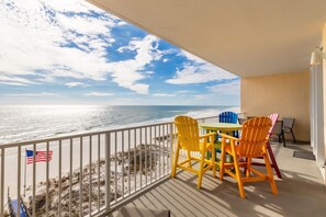 A balcony with a view of the ocean, featuring a table and chairs. - San Carlos 705: Dreamy Gulf Front Condo (Gulf Shores)