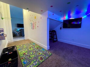 A room with a play area, a TV mounted on the wall, and a colorful rug. - Entrada at Moab 620 and 624 (Moab)