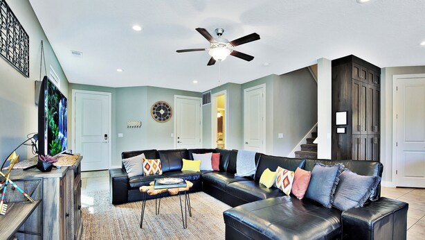 A modern living room with a sectional sofa, a coffee table, and a ceiling fan. - Entrada at Moab 620 and 624 (Moab)