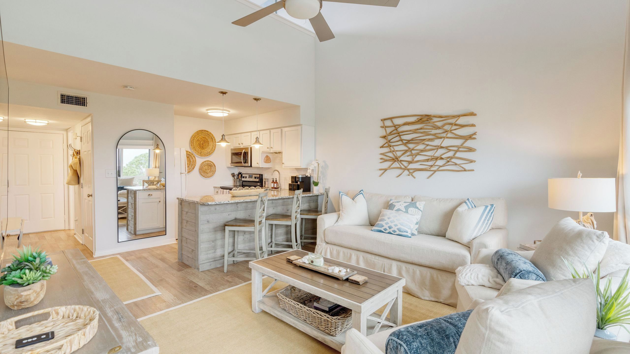 A modern living room with a sofa, coffee table, and a kitchen area with a bar.