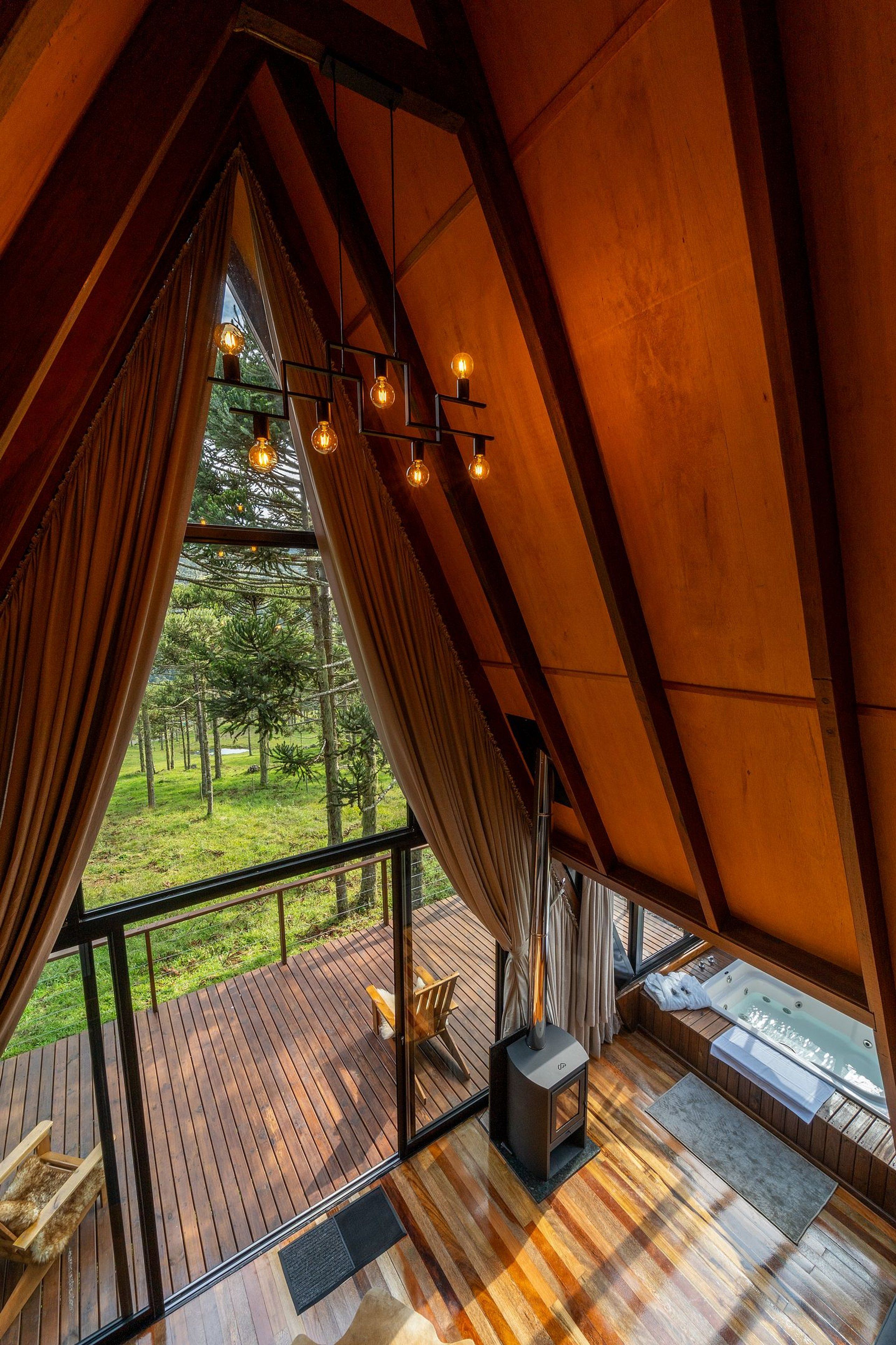A cozy cabin with a wooden deck, a hot tub, and a fireplace.