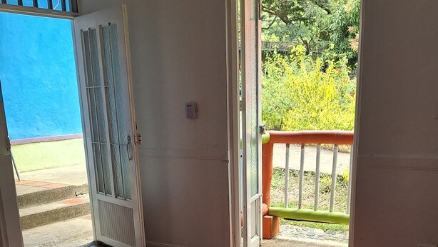 Quarto com duas camas, porta para o exterior e vista para o verde.