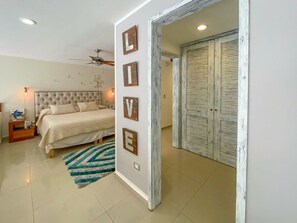 Une chambre avec un lit, un miroir fixé au mur et un panneau indiquant « EN DIRECT ».