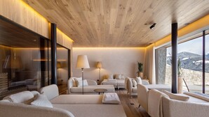 Ein modernes Interieur mit Holzboden, großen Fenstern und einer Sitzecke mit Sofas und einem Tisch.