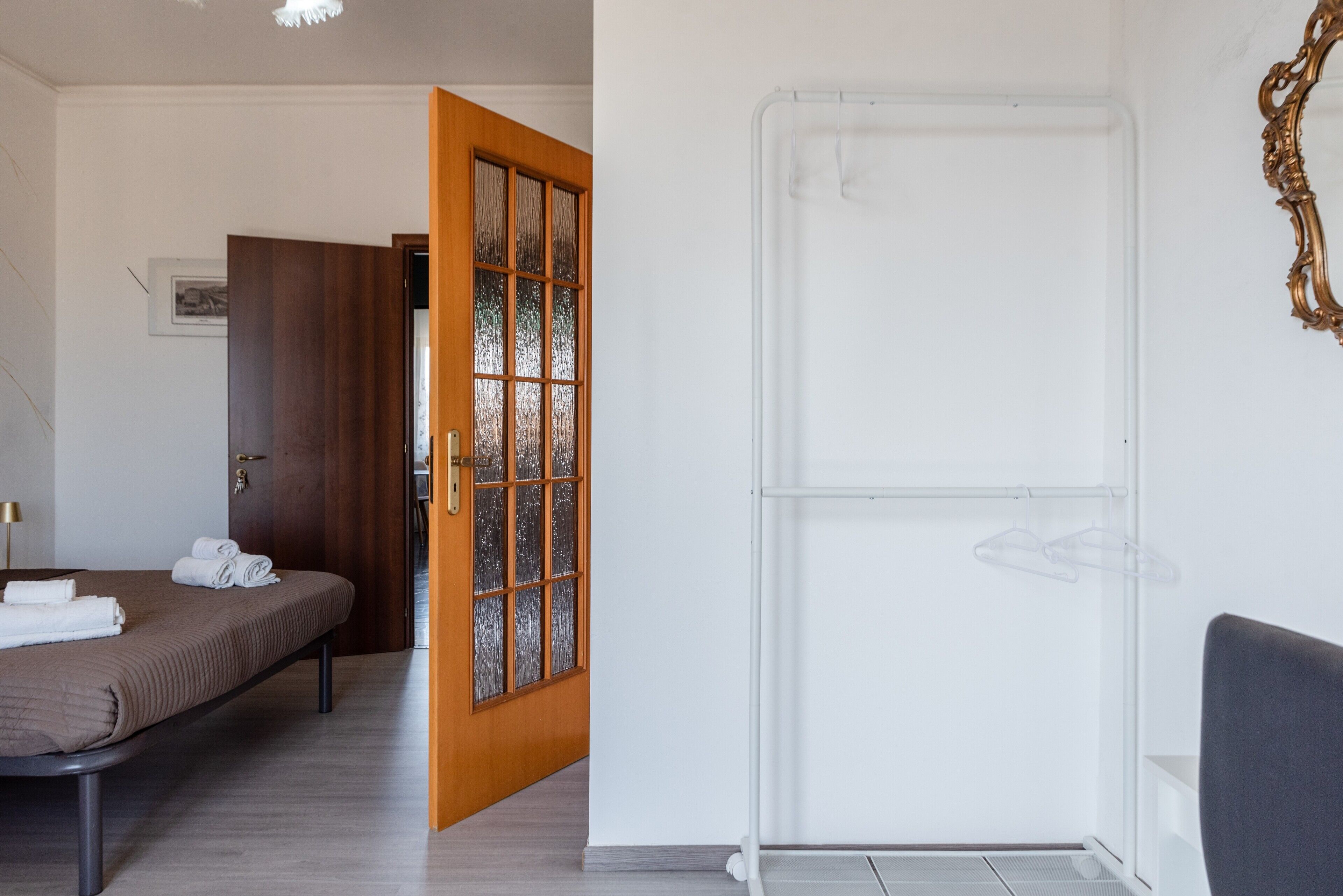 Ein Hotelzimmer mit Bett, Tür, weißer Wand und Fenster.