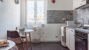 Une cuisine équipée d’une table à manger, de chaises, d’un four à micro-ondes et d’une cuisinière.