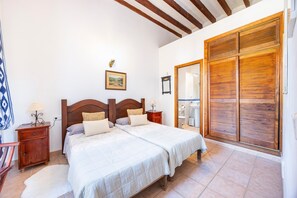 A bedroom with a double bed, wooden headboard, bedside tables, a nightstand, a mirror, and a wardrobe. - Room 'Habitación 4' with Mountain View, Shared Pool and Wi-Fi (Puigpunyent)