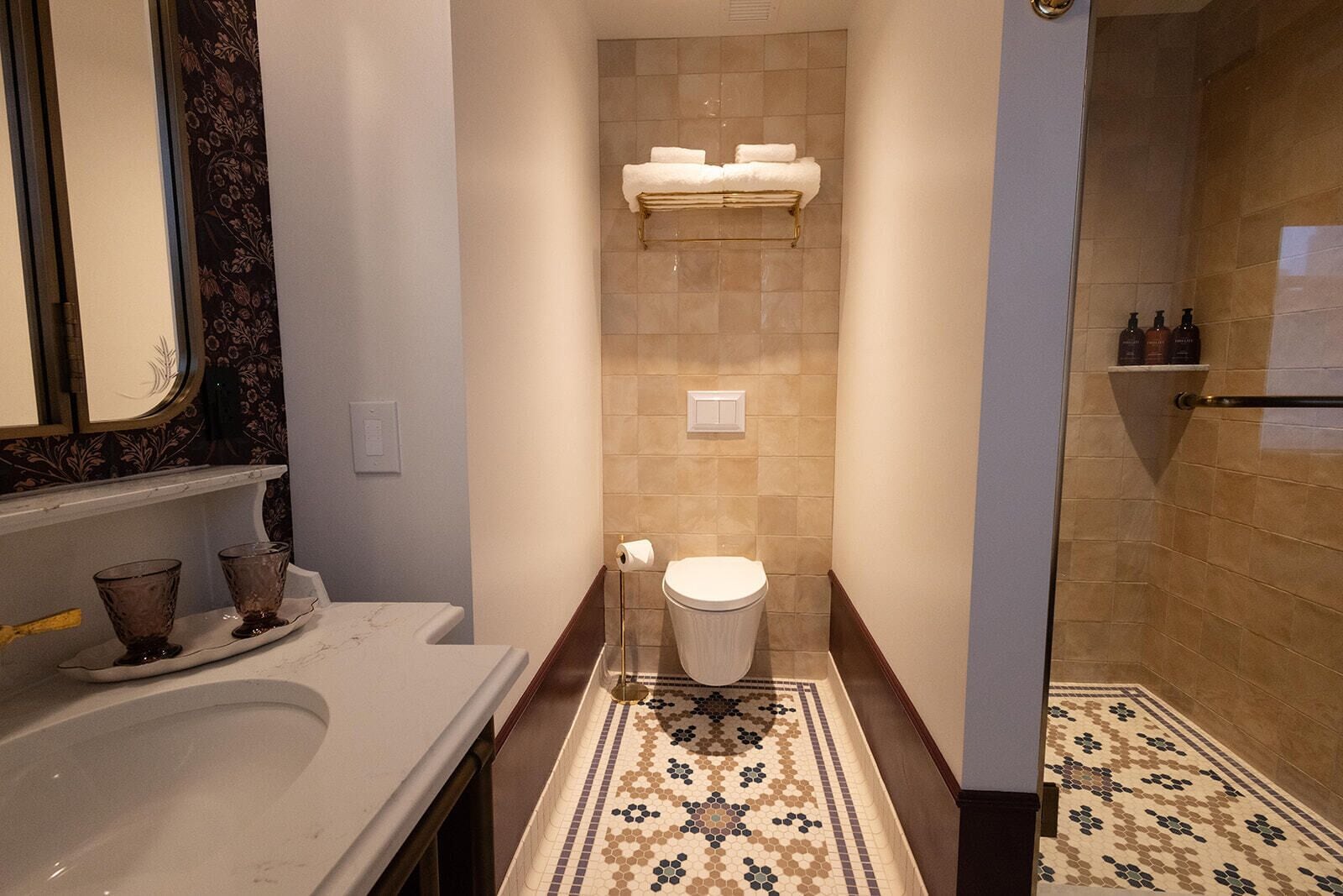 Een badkamer met een wit wastafel, toilet en douche.