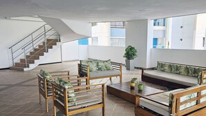 A spacious living area with a staircase, a sofa set, and a coffee table. - PARCEROS GROUP - 2 BEDROOM VACATION APARTMENT, 6TH FLOOR, CARTAGENA, SPAIN (Cartagena de Indias)