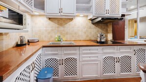 A kitchen with white cabinetry, a microwave, a sink, and a stove.