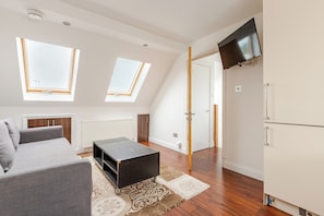 Relax in this spacious living area with a sofa, coffee table, and flat-screen TV.