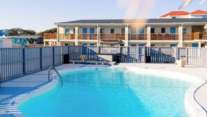 Une piscine dotée d’une terrasse en bois et d’un panneau indiquant qu’il est interdit de plonger.