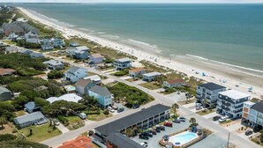 Zona residencial costera con casas, una playa y una piscina.