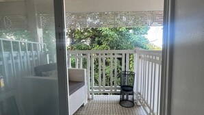 A covered balcony with a tiled floor, white railings, and a wicker sofa. - villa ji (Las Terrenas)