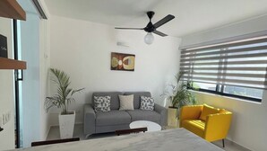 A modern living room with a grey sofa, a yellow armchair, a ceiling fan, and a painting on the wall. - villa ji (Las Terrenas)