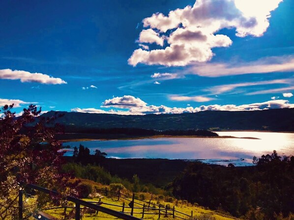 Un lago con cielo despejado y montañas al fondo.