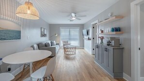 Um espaço moderno para viver com área de refeições, cozinha e espaço para sentar.