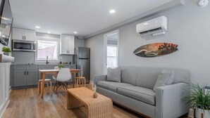 Un apartamento moderno con kitchenette, comedor y sala de estar.