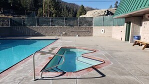 Una piscina con un trampolín y una zona vallada.