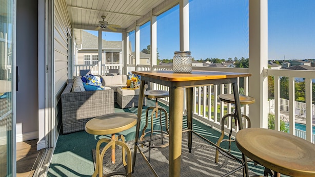 A covered outdoor area with a table, chairs, and a sofa. - Myrtle Beach / Surfside Beach Condo: 3 Mi to Ocean (Myrtle Beach)