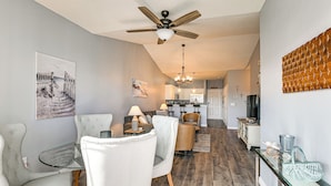 A modern kitchen with white cabinets, a dining area with a glass table, and a ceiling fan. - Myrtle Beach / Surfside Beach Condo: 3 Mi to Ocean (Myrtle Beach)