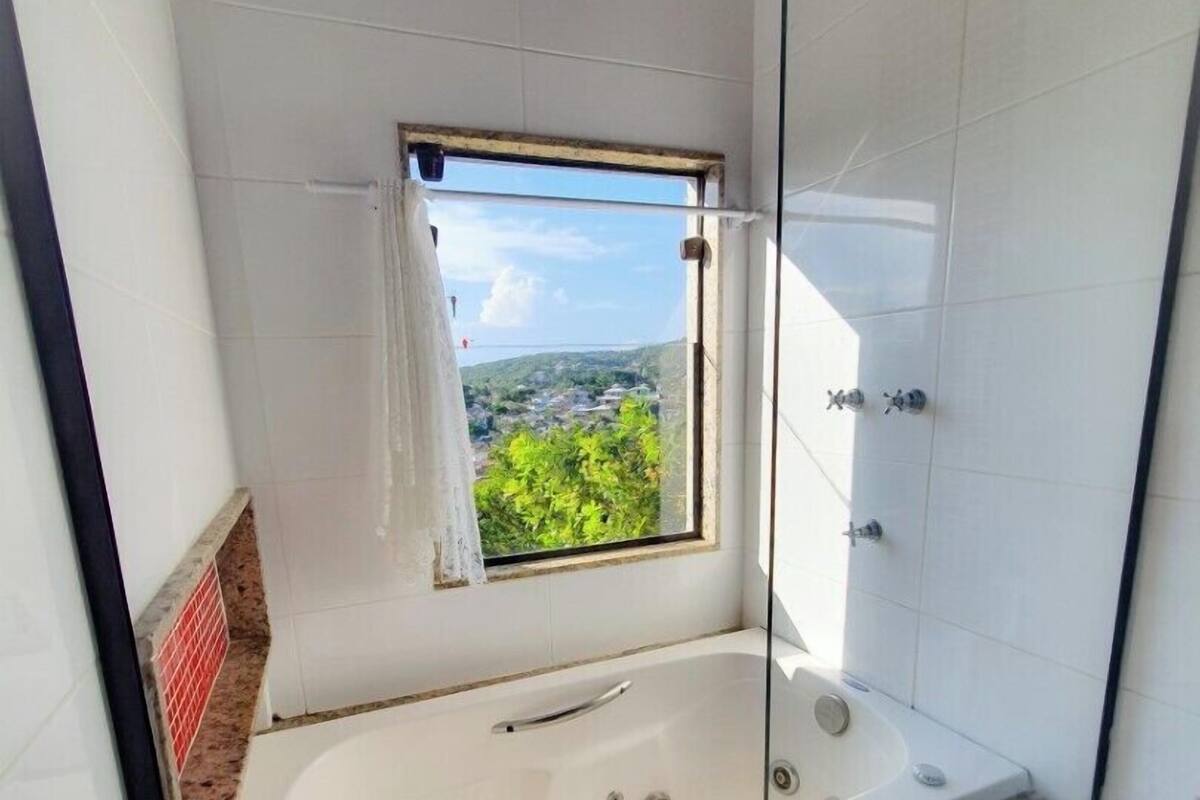 Um banheiro com banheira, janela com vista e área de chuveiro.