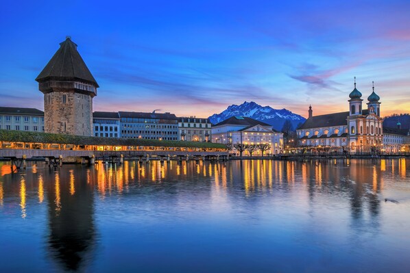 A historic town with a tower, a church with domes, and a mountain in the background. - LEVA Stay Luzern-Interlaken I Nature I Familie (Sarnen)