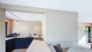 A modern kitchen with dark cabinets, a long countertop, and a built-in sink.