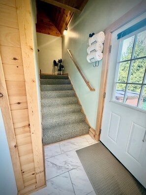 A staircase with carpeted steps leading to a room with a white door and window.