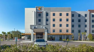 Welcome to our hotel, set amidst a tranquil landscaped area with palm trees and shrubs.