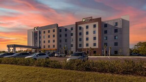 A hotel with multiple floors, a parking lot, and a sunset sky. - Comfort Suites Fort Myers East I-75 (Fort Myers)