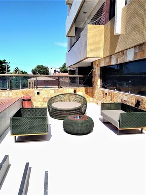 Relax on the patio with a round wicker table, ottoman, and sofas.