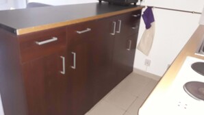 A kitchen with dark wooden cabinets, a microwave, and a stove. - 2* apartment in the mountains (Luz-Saint-Sauveur)