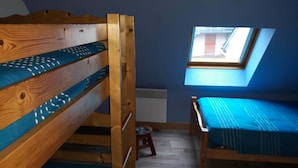 A small, cozy room with a bunk bed and a single bed, a skylight, and a radiator. - 2* apartment in the mountains (Luz-Saint-Sauveur)