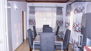 A dining area with a rectangular table and six grey upholstered chairs. - Mongi Guest House (Harare)