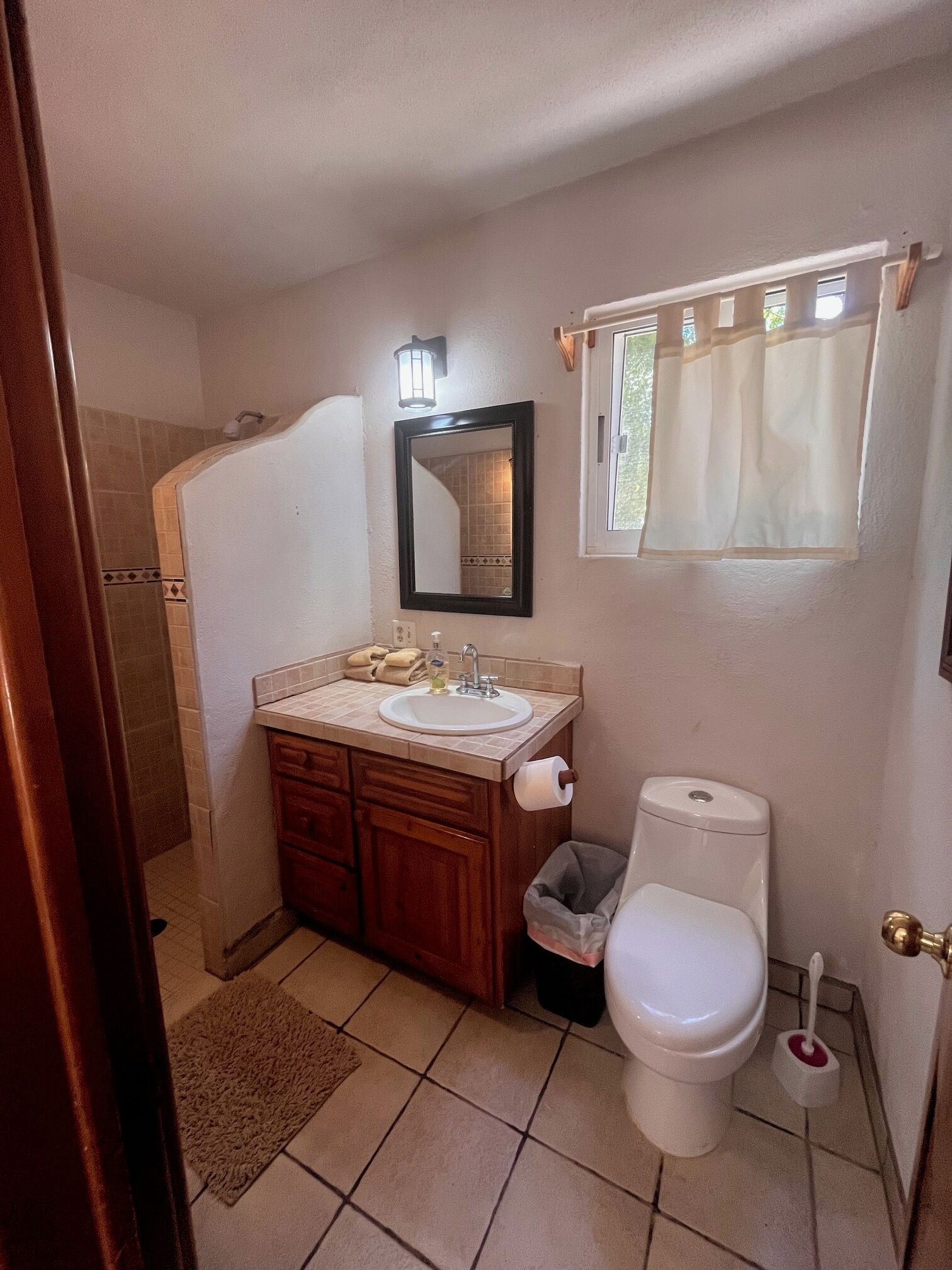 Une salle de bain équipée d’un lavabo, d’un miroir, de toilettes et d’une douche.