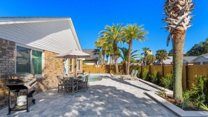 A backyard with a barbecue, pool, patio furniture, and palm trees. - Coastal Charm, Private Pool, Private Beach Access! (Destin)